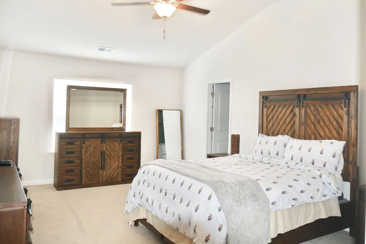 A calm bedroom scene featuring a bed, dresser, and plenty of natural light streaming onto easy-clean flooring. The space feels bright, airy, and uncluttered, emphasizing the practical benefits for pet owners—such as durable floors and comfort for both pet and owner.